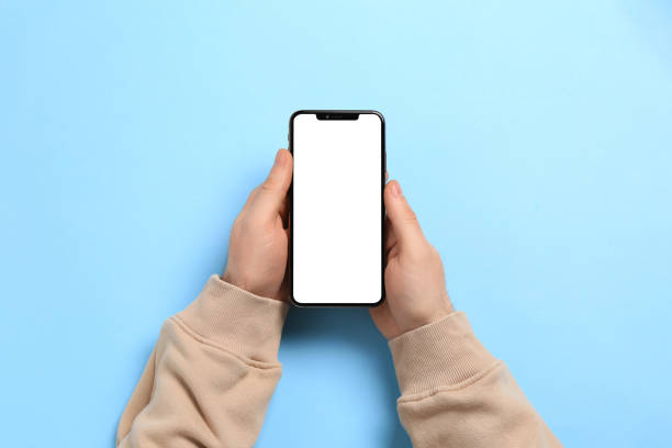 istock Man with smartphone on light blue background, top view 1449088225
