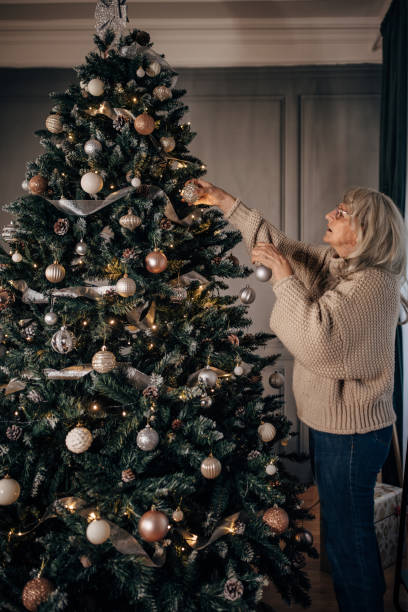 istock Senior woman decorating Christmas tree at home 1449088542