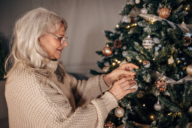 istock Senior woman decorating Christmas tree at home 1449088653