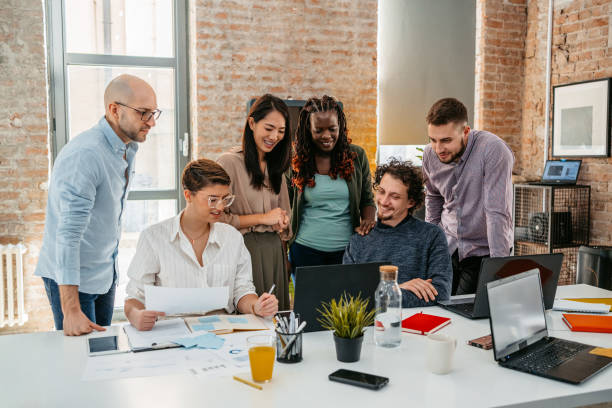 istock Colleagues Watching Something On Laptop While At The Office 1449089184
