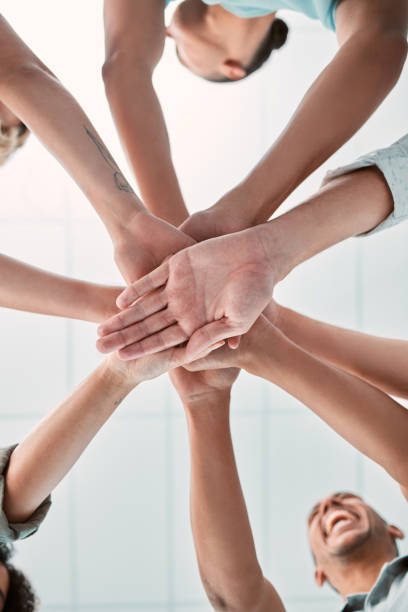 istock Hands, collaboration and unity with a business team in a huddle or circle in the office together from below. Meeting, success and motivation with a man and woman group standing in solidarity 1449091510
