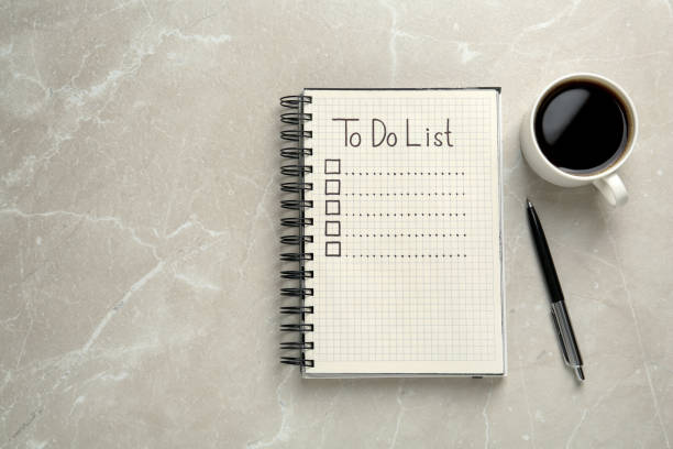 istock Notepad with unfilled To Do list, pen and cup of coffee on light grey marble table, flat lay. Space for text 1449091692