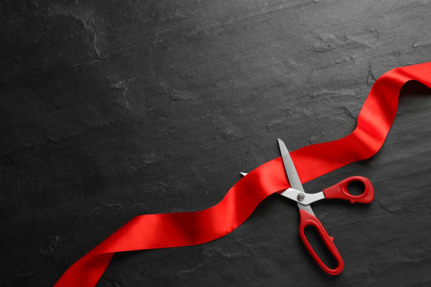istock Red ribbon and scissors on black background, top view. Space for text 1449093480
