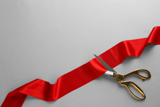 istock Red ribbon and scissors on light grey background, top view. Space for text 1449094071