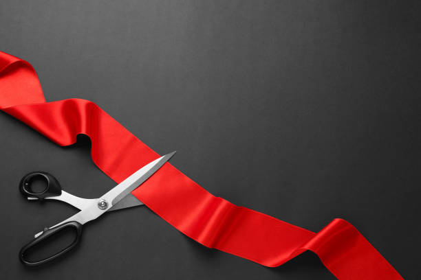 istock Red ribbon and scissors on black background, top view. Space for text 1449094086