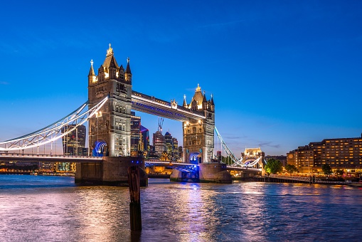 A scenic shot of the Tower Bridge and the city skyline in London, Europe during dusk