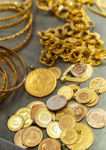 Close-up of gold jewelry and gold coins in the store