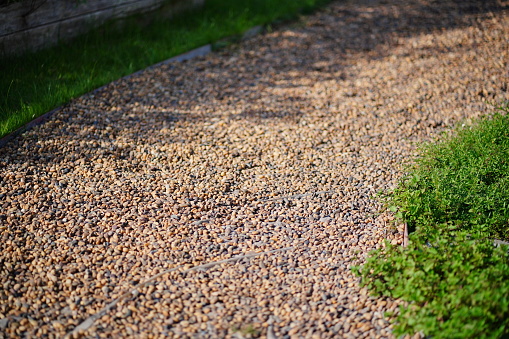 Footpath built with pebbles with side green grass