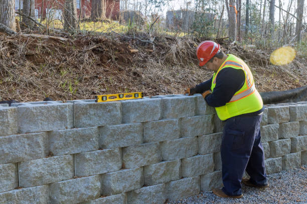 istock Man with leveling tool building retaining block wall with being built on new property 1449102273