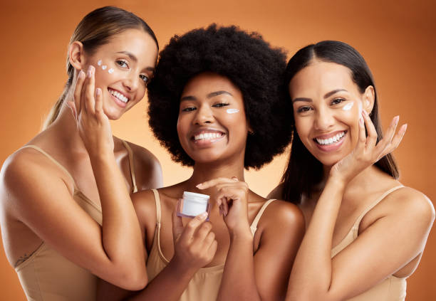 Beauty, face cream skincare and women portrait moisturizer, healthy aesthetic and glowing skin on orange studio background. Happy diversity friends group facial product, makeup cosmetics and wellness belleza, crema facial para el cuidado de la piel y crema hidratante para retratos para mujeres, estética saludable y piel brillante sobre fondo de estudio naranja. feliz diversidad amigos grupo de productos faciales, maquillaje cosméticos y bienestar