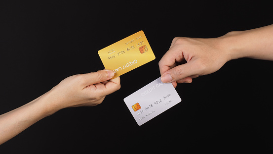 Two hands is hold silver and gold credit card on white background.