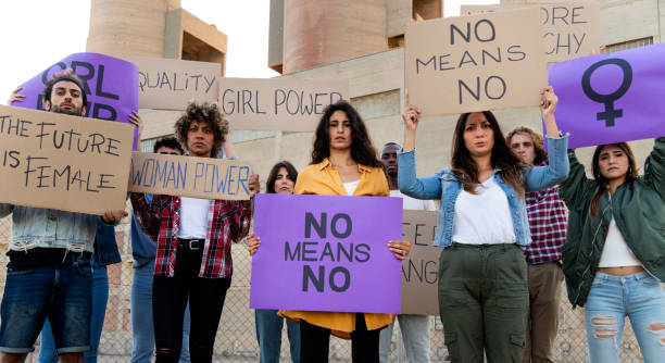 istock Multiracial demonstrators looking at camera holding protest signs for women's rights and equality. Panoramic banner. 1449105435