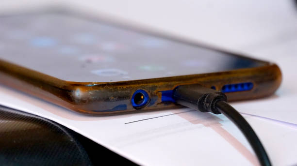 istock Close-up view of old dusty android smartphone charging port with usb-c cable 1449112186