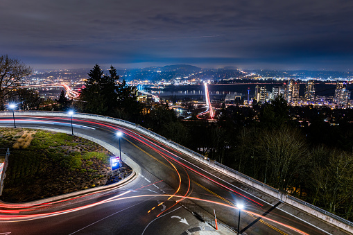 Shot from a high altitude vantage point, a busy city with traffic lights, large buildings, and overpasses. This image illustrates connection and travel. Shot in Portland Oregon.