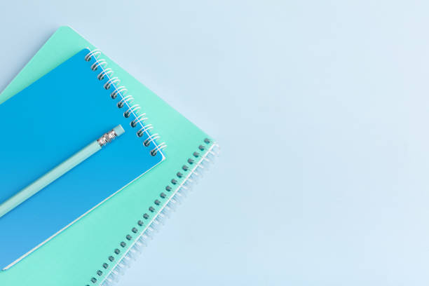 istock Blue notepad and pencil on a blue background. Place for your text 1449122987
