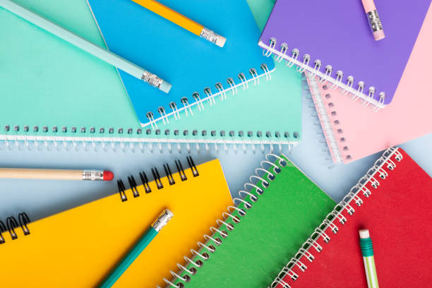 istock colored notebooks, colored pencils on a light table. Place for your text. 1449123096