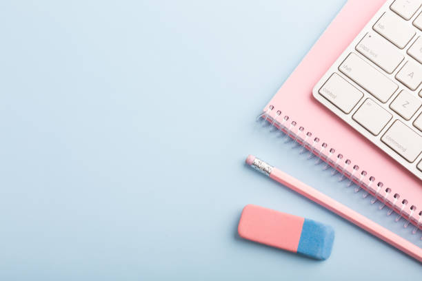 istock Pink notebook and pencil on a blue background. Place for your text 1449123616