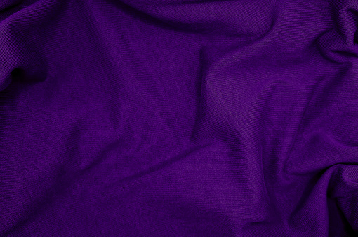 luxury purple coarse calico fabric. canvas violet cloth texture background used for calico textile, wavy fabric background. crumpled fabric texture background. creases of satin, silk, and cotton.