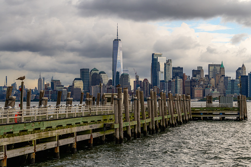 Pier at the Liberty Island with seagulls and downtown of Manhattan in the background.
