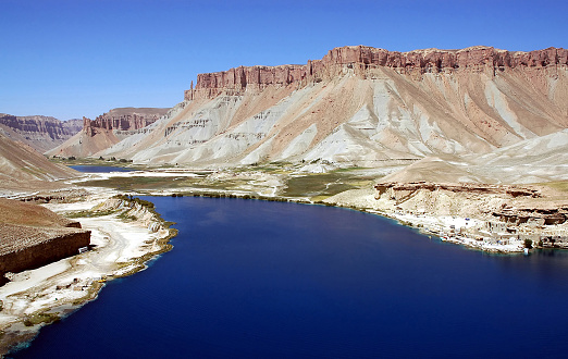 Band-e Amir lakes near Bamyan (Bamiyan) in Central Afghanistan. The blue lakes at Band e Amir national park are formed by travertine dams. Travertine wall, lake and mountains, Band e Amir, Afghanistan