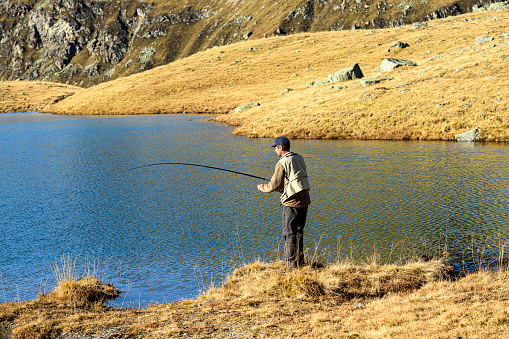 Fisherman fishing in a lake in the mountains
