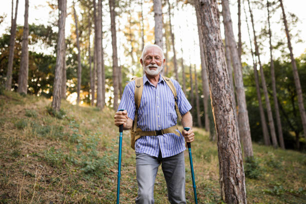 istock Senior man using hiking poles on a hike 1449139889