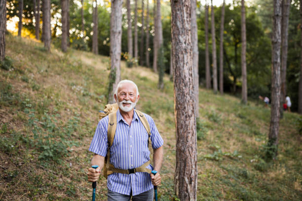 istock Senior man using hiking poles on a hike 1449139938