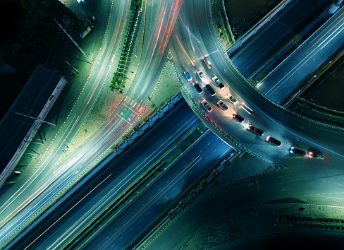 Expressway top view, Road traffic an important infrastructure, car traffic transportation above intersection road in city night, aerial view cityscape of advanced innovation, financial technology
