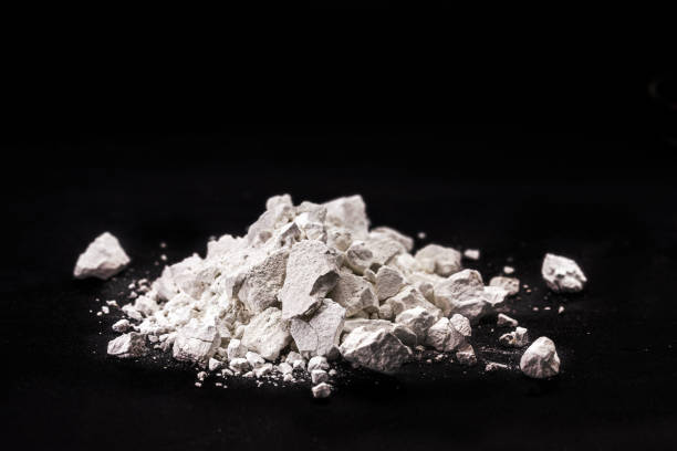 istock Calcium Chloride flakes, salt in solid state, used in brine for refrigeration machines, road dust and ice control, in cheese and in cement. Industrial use, isolated black background, copyspace 1449142133
