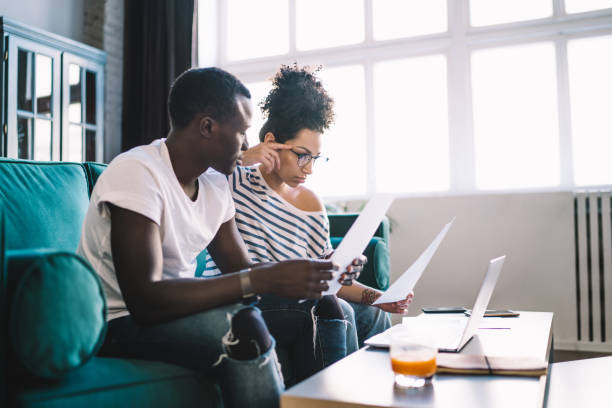 istock Concentrated couple sitting with documents at home 1449142390