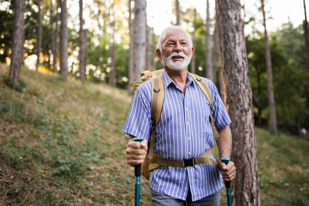 istock Senior man using hiking poles on a hike 1449142517