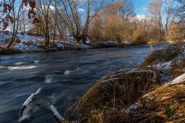 Fast flowing Malse river in winter cold day near big Ceske Budejovice city