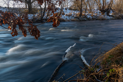 Fast flowing Malse river in winter cold day near big Ceske Budejovice city