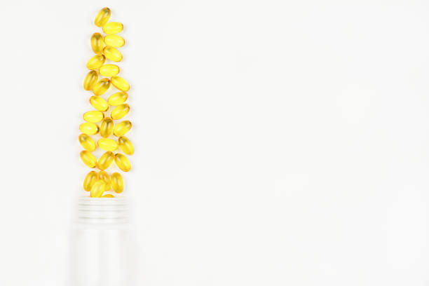 istock Yellow omega 3 capsules with bottle on white background 1449150193