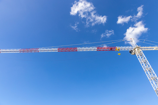 Low ale view of Tower crane at construction in city, sky background with copy space, full frame horizontal composition