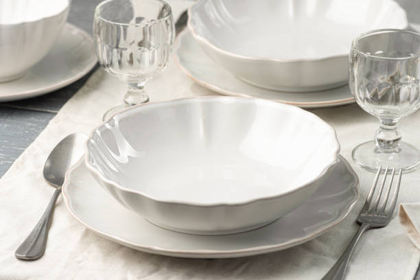 istock Empty plates and cutlery with wine glasses on a linen tablecloth. High angle view. 1449156940