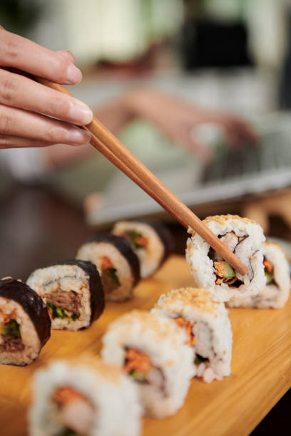 Woman Eating Delicious Homemade Sushi stock photo