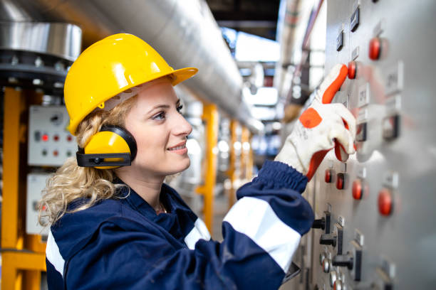 portrait of female factory electrician checking voltage and installations in power plant. - power equipment imagens e fotografias de stock