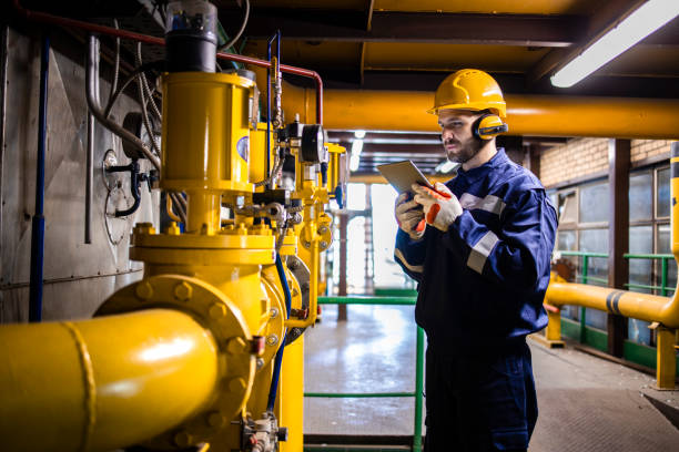 istock Industrial worker checking gas pipe pressure and consumption in refinery plant. 1449160907