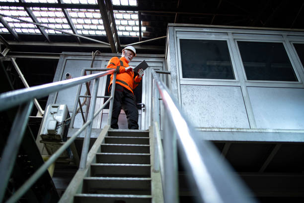 istock Industrial engineer worker wearing safety uniform and hardhat standing by control room and checking production on tablet computer. 1449161411
