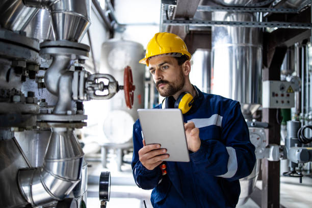 istock Worker supervisor in district heating plant doing quality control and inspection of pipes and valves. 1449163146