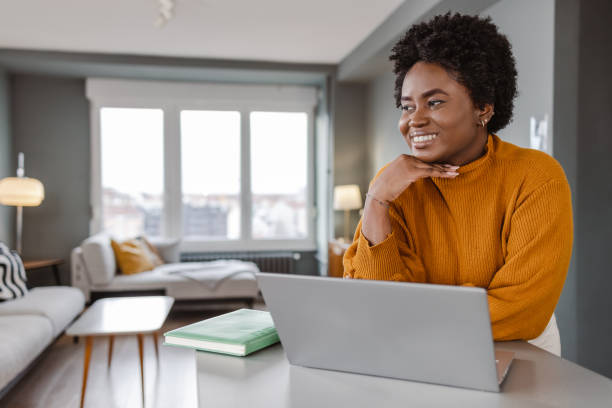 istock Young woman daydreaming while working at home 1449163740