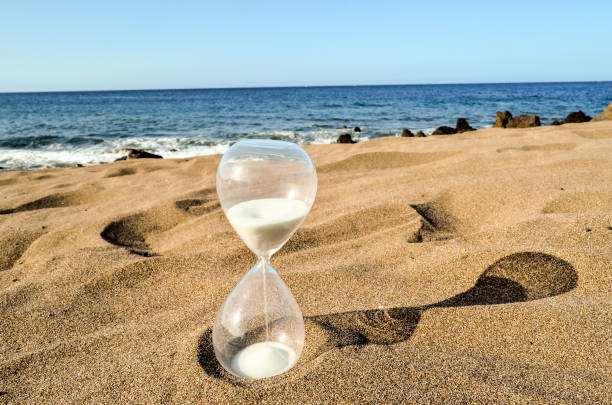 istock Hourglass Clock on the Sand Beach 1449165430