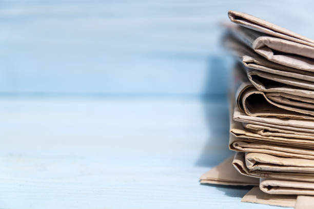 istock Stack of newspapers to read on blue background with advertising space 1449174895