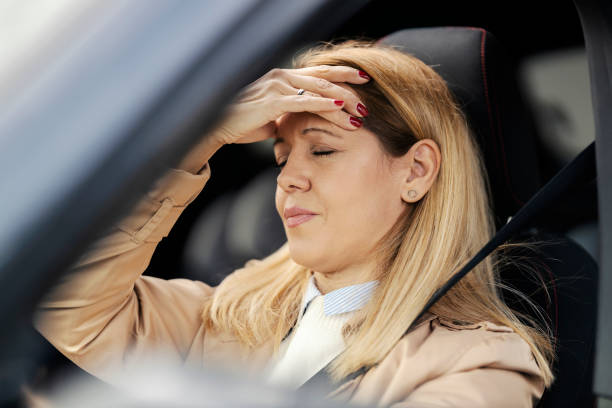 istock A female driver sitting in her car and having headache. 1449175829