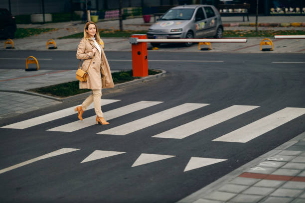 istock A middle aged woman is crossing a crosswalk downtown. 1449176422