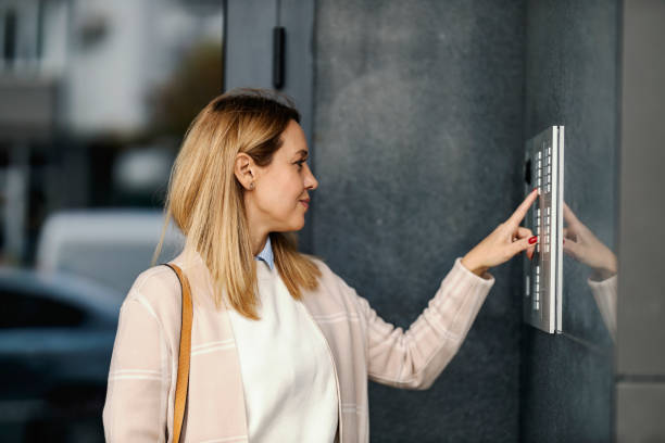 istock Profile of a middle-aged woman ringing on intercom on a building downtown. 1449177572