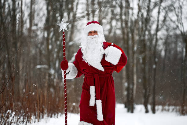 Santa Claus with magic staff and sack of Christmas gifts. stock photo