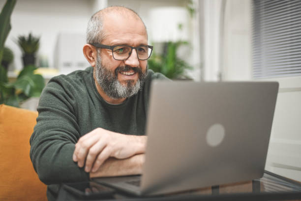 Mature man working from home stock photo