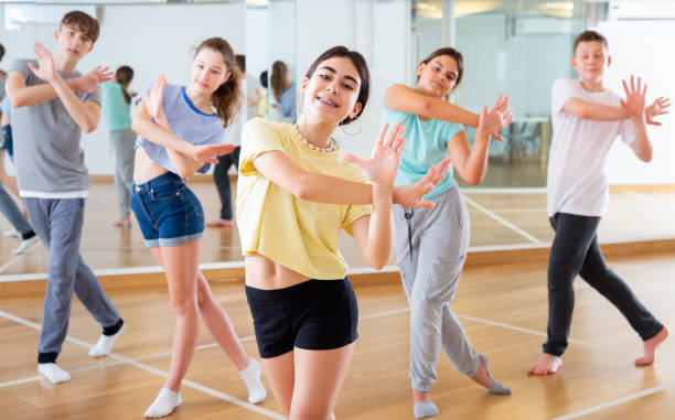istock Diligent friendly smiling teenagers learn dance movements 1449193299